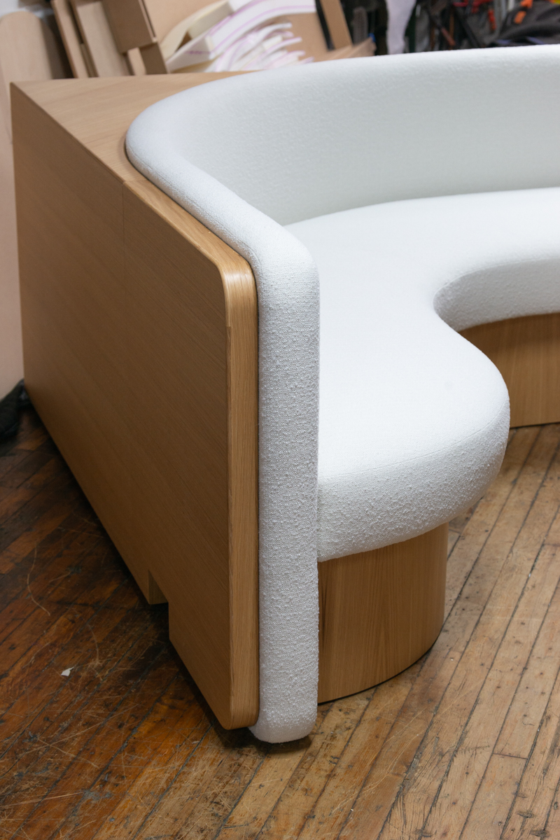 Custom dining banquette with white oak frame and boucle upholstery