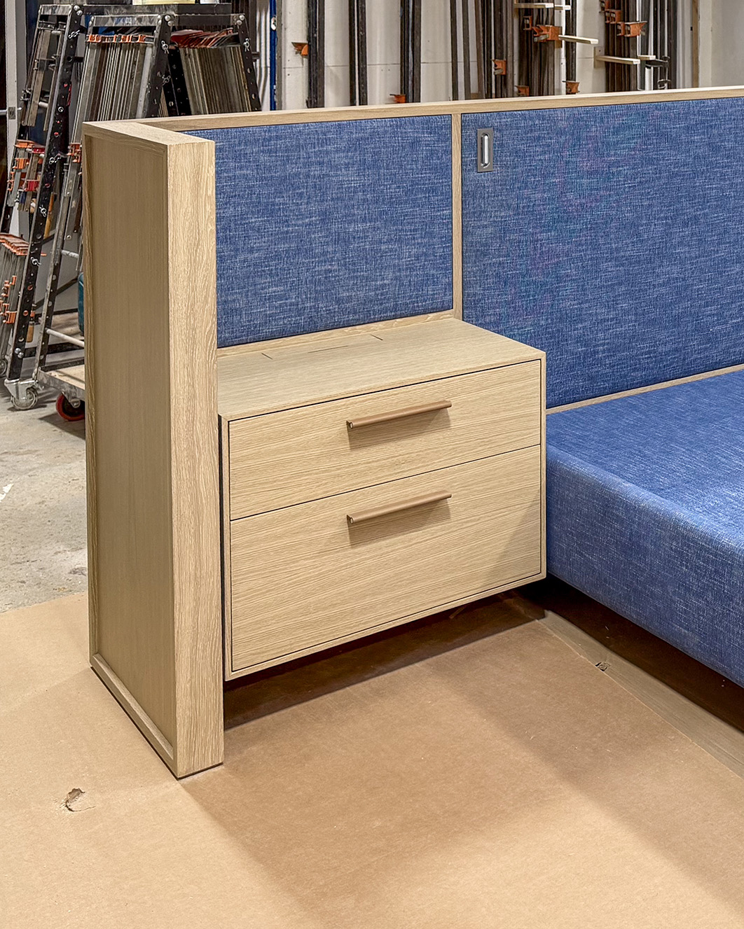 Custom white oak nightstand integrated into upholstered bed frame